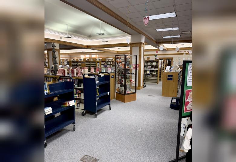 Interior view of the Osage Public Library showing book sacks, display shelves, and featured title carts arranged throughout the main floor.